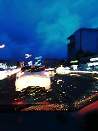 Illuminated city street against sky at night