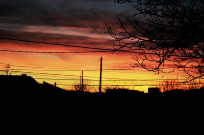 Silhouette electricity pylon against sky during sunset