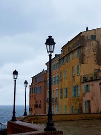 Street light by building against sky