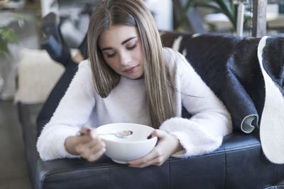 Young woman having breakfast at home