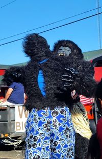 Rear view of person standing against blue sky