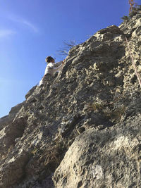 Low angle view of rocks on mountain against sky