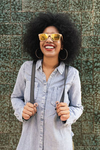 Portrait of a smiling young woman wearing sunglasses