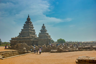 Group of people outside temple against sky