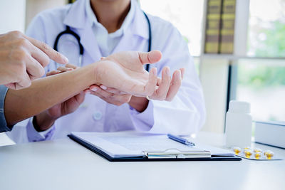 Midsection of female doctor examining patient in office