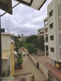 High angle view of buildings by street against sky