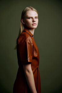 Young woman standing against gray background