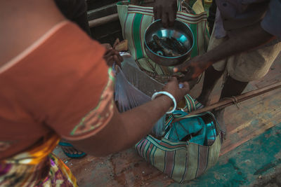 High angle view of woman taking food from vendor at home