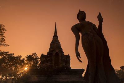 Statue of historic building against sky during sunset