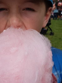 Close-up portrait of boy eating cotton candy