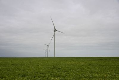 Windmill on field against sky