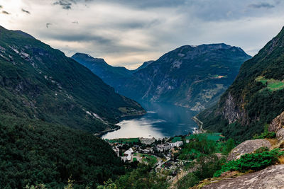 Scenic view of lake by mountains against sky