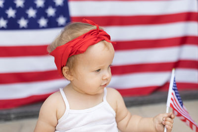 Close-up of cute girl holding american flag