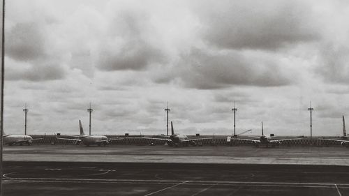 Airplane on airport runway against sky