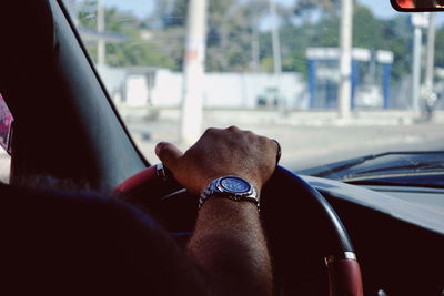 Cropped hand of man driving car