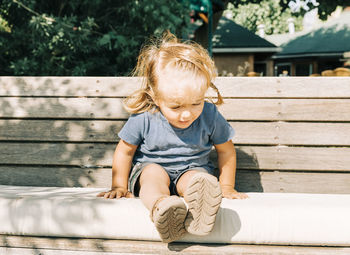 Full length of boy sitting outdoors