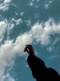 Low angle view of silhouette hand against sky