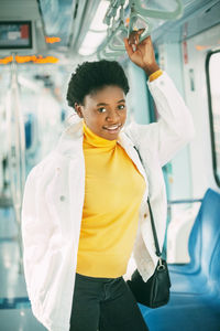 Portrait of young standing in subway train