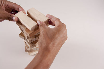 Close-up of hand holding toy against white background