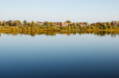 Scenic view of lake by building against clear sky