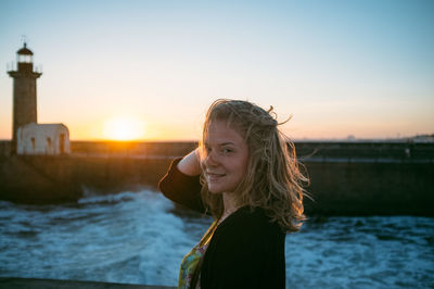 Young woman looking at sea at sunset