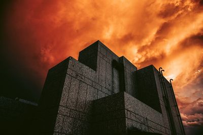 Low angle view of modern building against sky during sunset