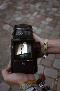 High angle view of hands holding camera