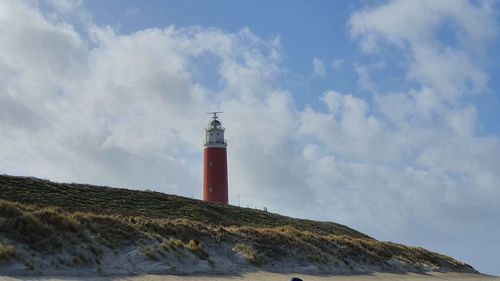 Lighthouse by sea against sky