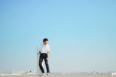 Full length of man standing on sea against clear sky