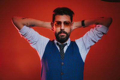 Portrait of young man against red background