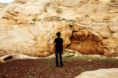 Rear view of man standing on rock