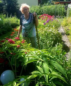 Rear view of woman standing amidst plants