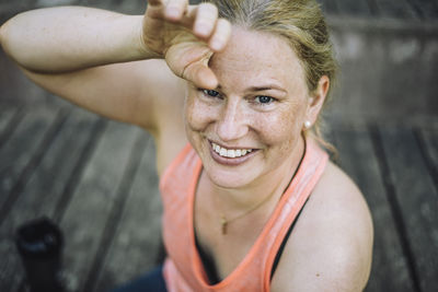 High angle portrait of smiling exhausted woman on steps