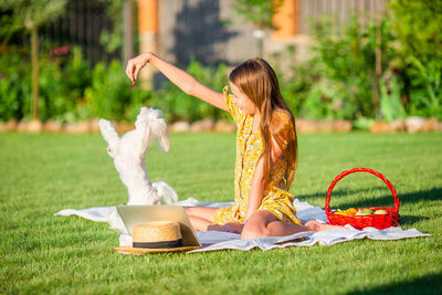 Rear view of woman sitting on field