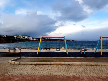 Play ground  on beach against sky