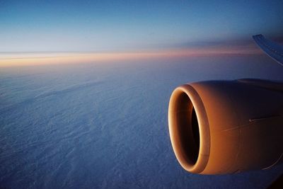 Close-up of airplane flying over sea against sky