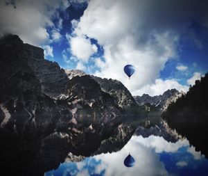 Scenic view of lake by mountains against cloudy sky