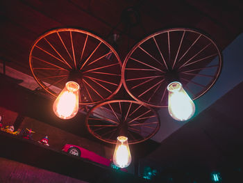 Low angle view of illuminated light bulbs hanging from ceiling