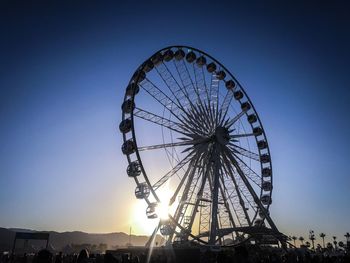Low angle view of ferris wheel against clear sky