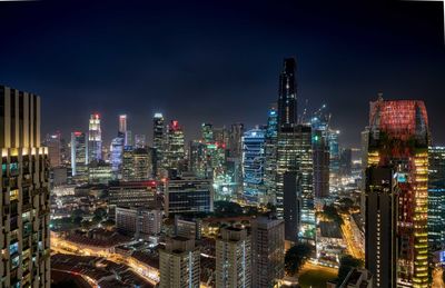 Illuminated cityscape against sky at night