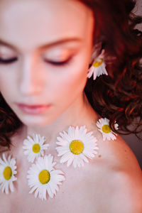 Close-up of beautiful young woman wearing flowers and make-up