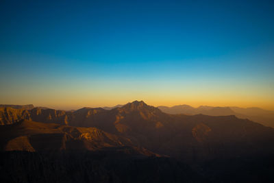 Scenic view of mountains against blue sky