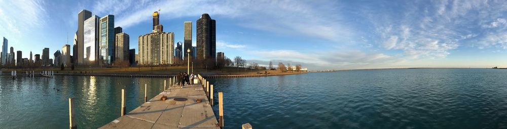 Panoramic view of buildings by sea against sky