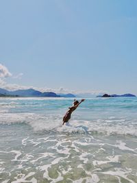 Scenic view of sea against sky woman jumping in water