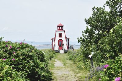 Tower amidst trees and buildings against sky