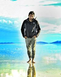 Portrait of man standing at beach against sky