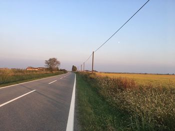 Road amidst field against sky