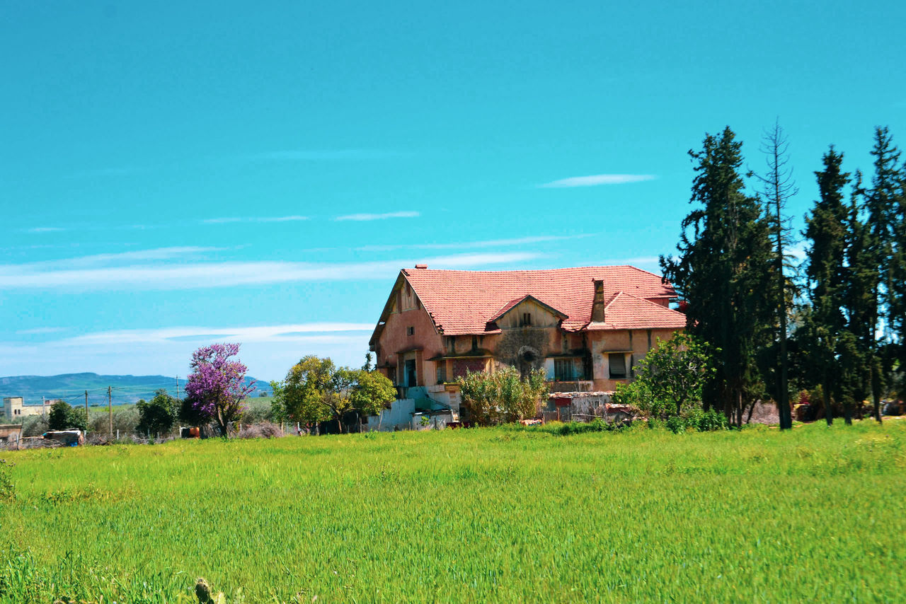 HOUSE ON FIELD AGAINST SKY