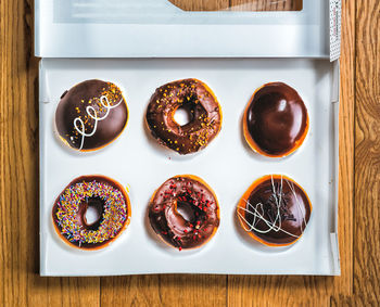 Directly above shot of donuts in box on wooden table