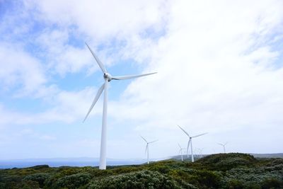 Windmill on field against sky